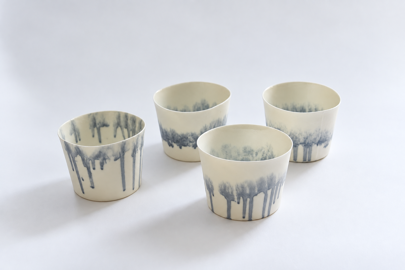 Four porcelain cups with delicate blue drawings
