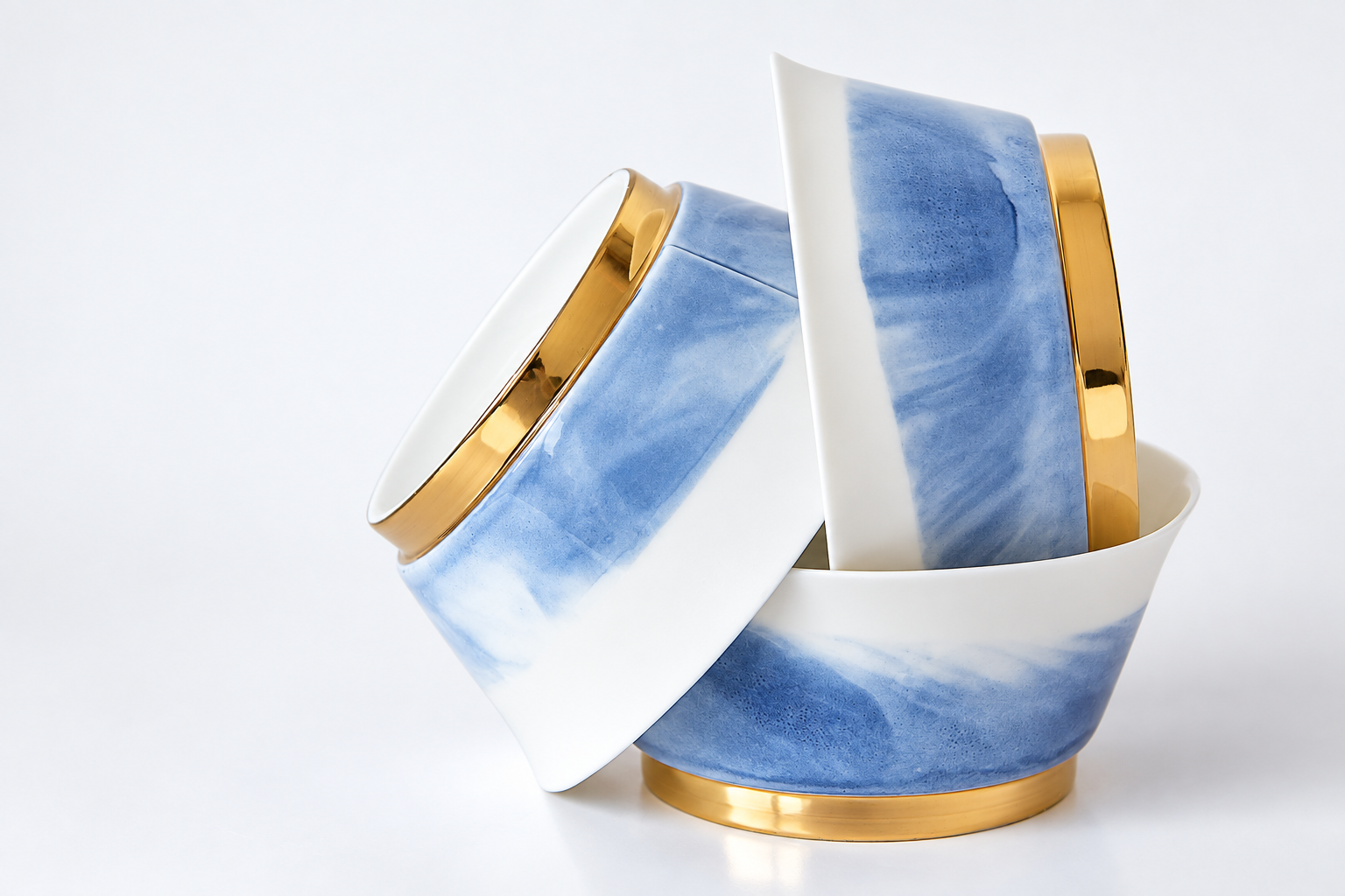 Drei blau-weiße Porzellanschalen mit goldenen Akzenten