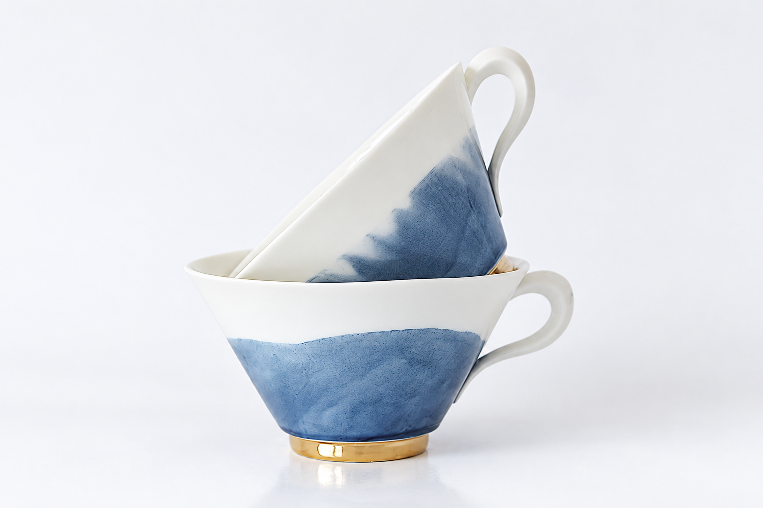 Zwei blau-weiße Porzellantassen mit goldenen Details